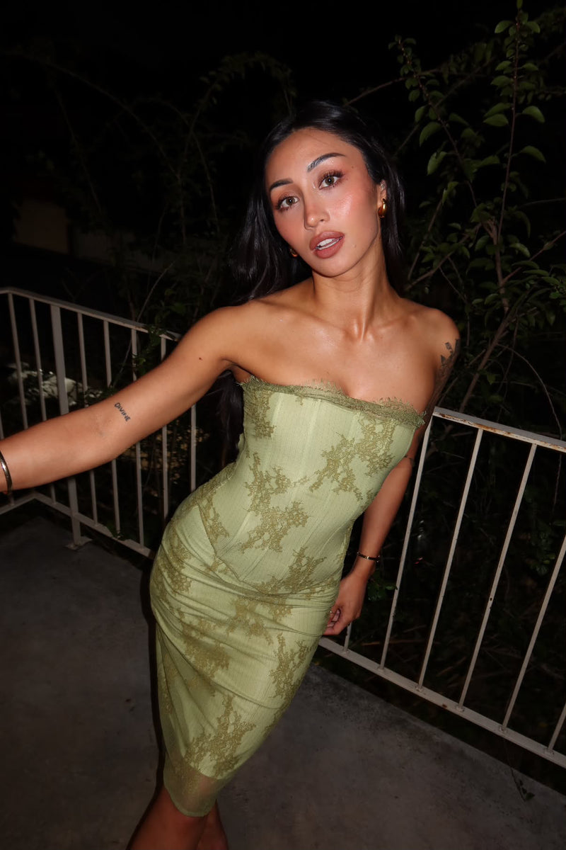 Girl outside posing for the camera in a green set standing in front of a fence. - @aishh.irawan