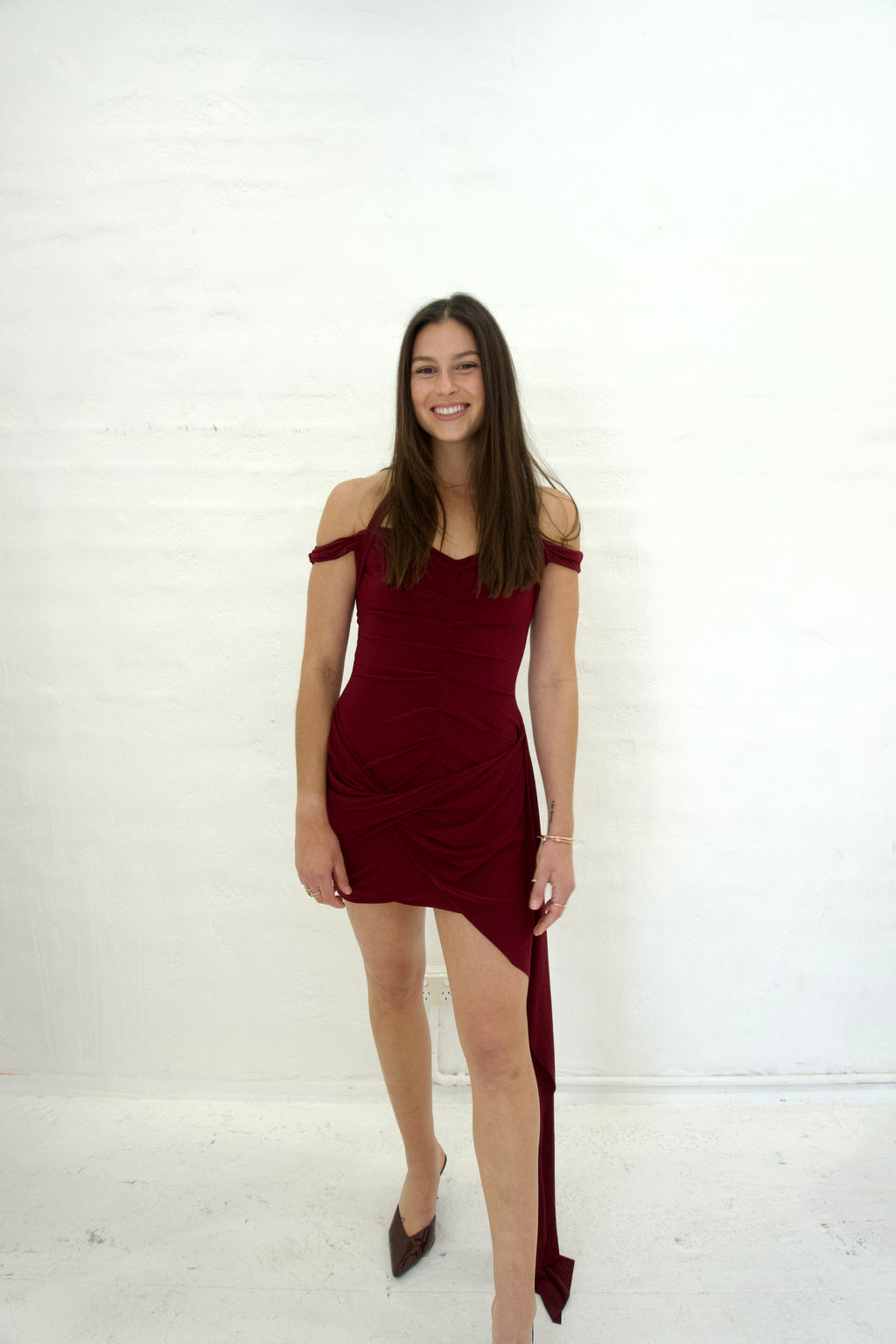 Woman wearing a burgundy dress with a white background