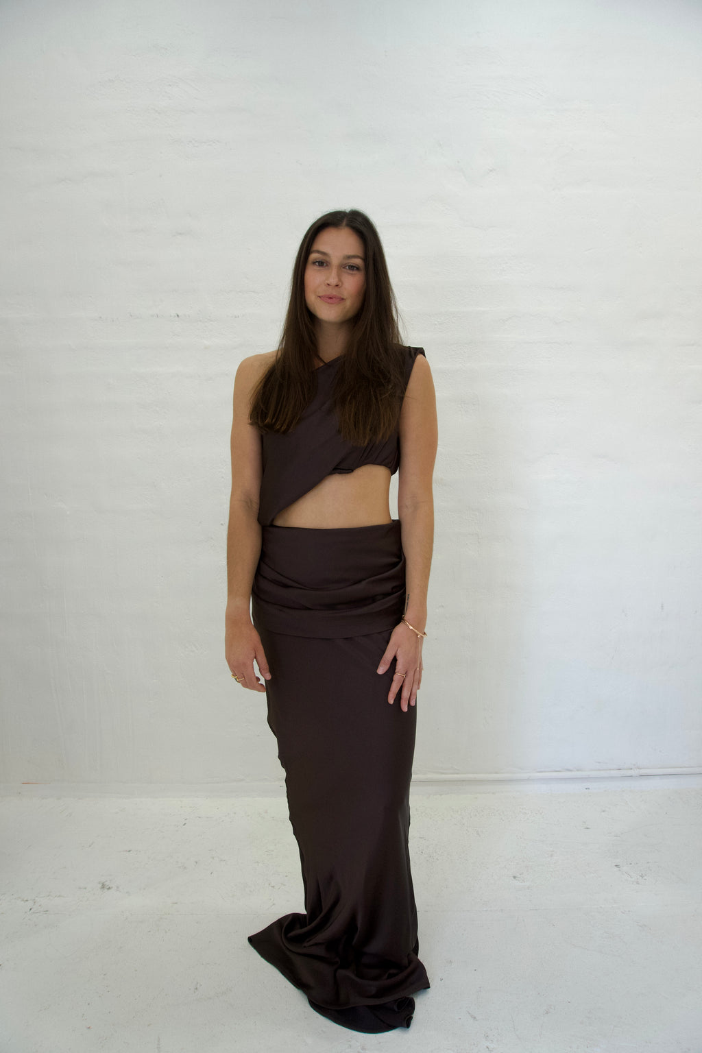 Woman wearing a dark brown dress against a white background