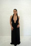 Woman wearing a black halter neck gown against a white background