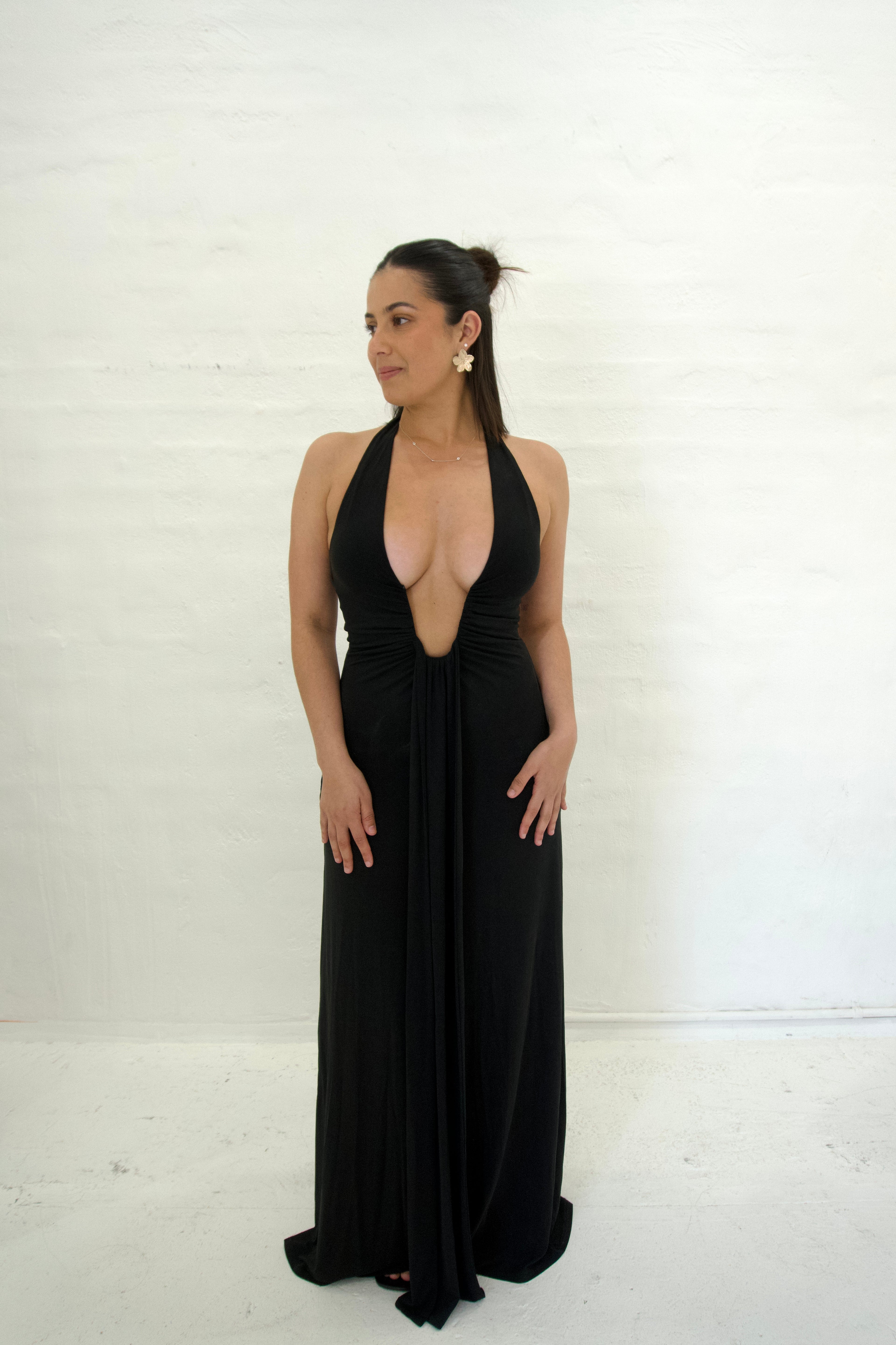 Woman wearing a black halter neck gown against a white background