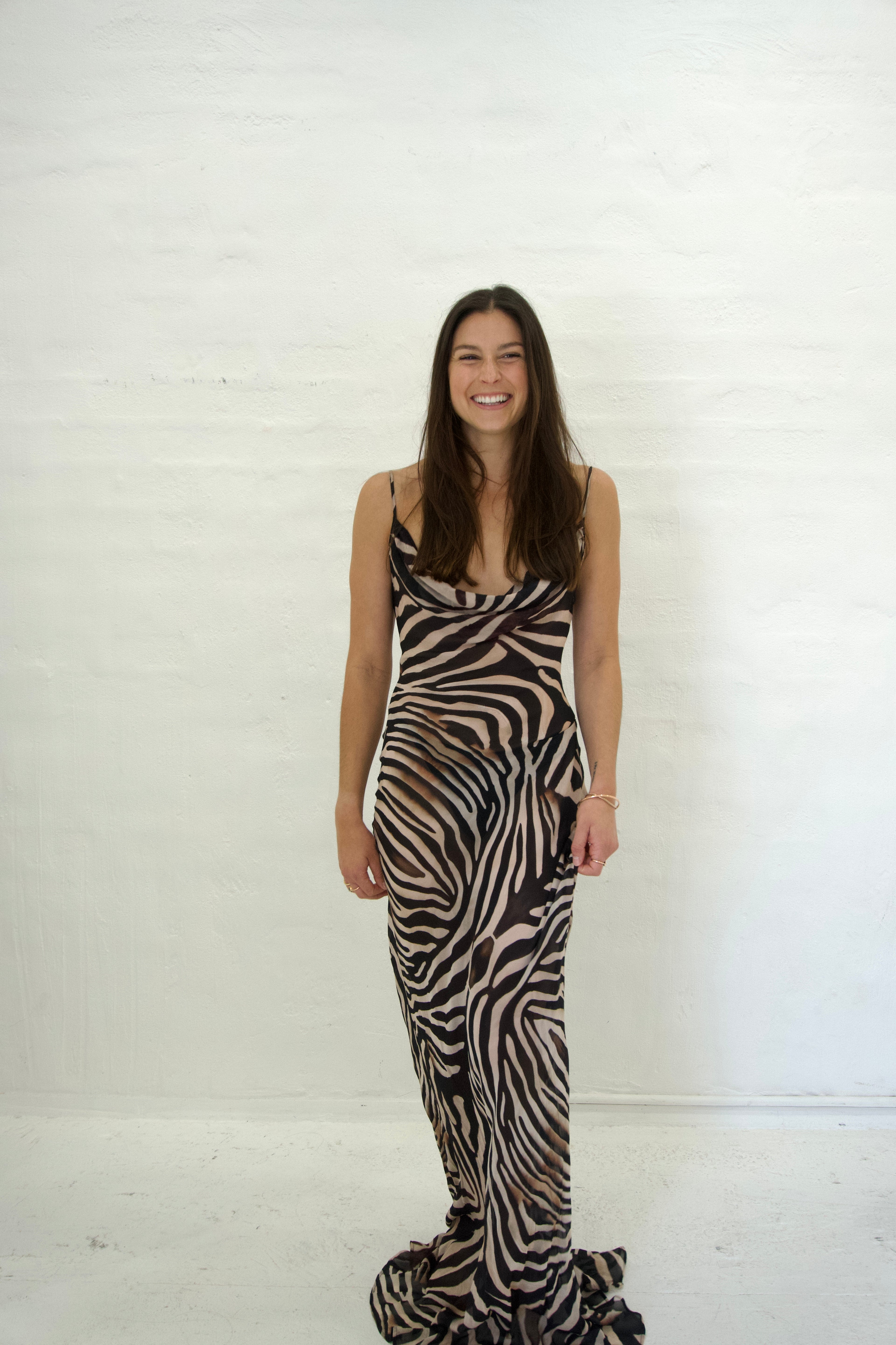 Woman wearing a zebra print dress against a white background