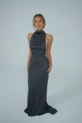 Women wearing a metallic turtle neck gown in front of a white backdrop. 