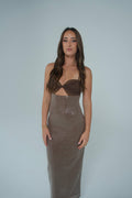 Front view of a woman wearing a brown cut-out bustier-style top paired with a high-waisted, floor-length brown sequin maxi skirt, photographed against a light studio backdrop.