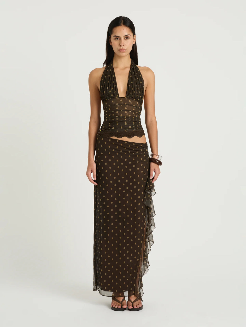 Woman wearing a brown polka dot dress on a white background
