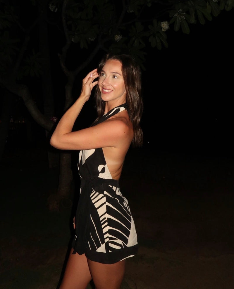Woman wearing a black and white dress with geometric patterns against a dark background. - @alesha.beggs