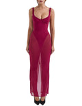 Woman wearing a magenta evening gown with sheer panels on a white background