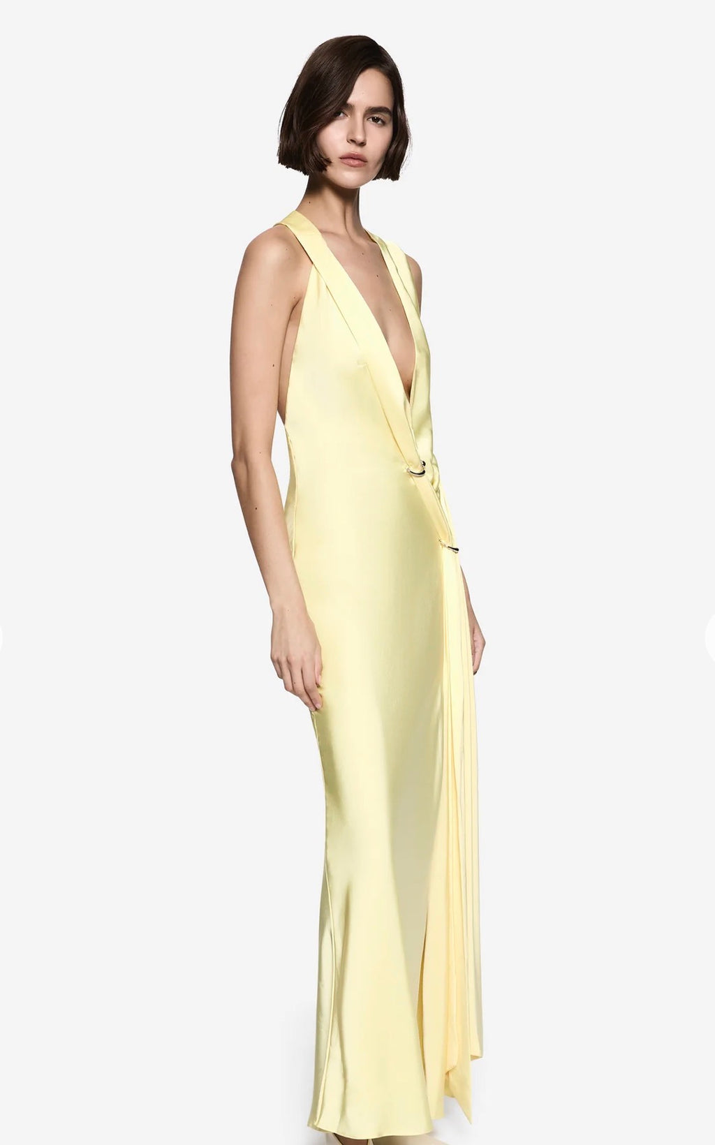 Women standing in front of a white backdrop in q yellow maxi satin dress.