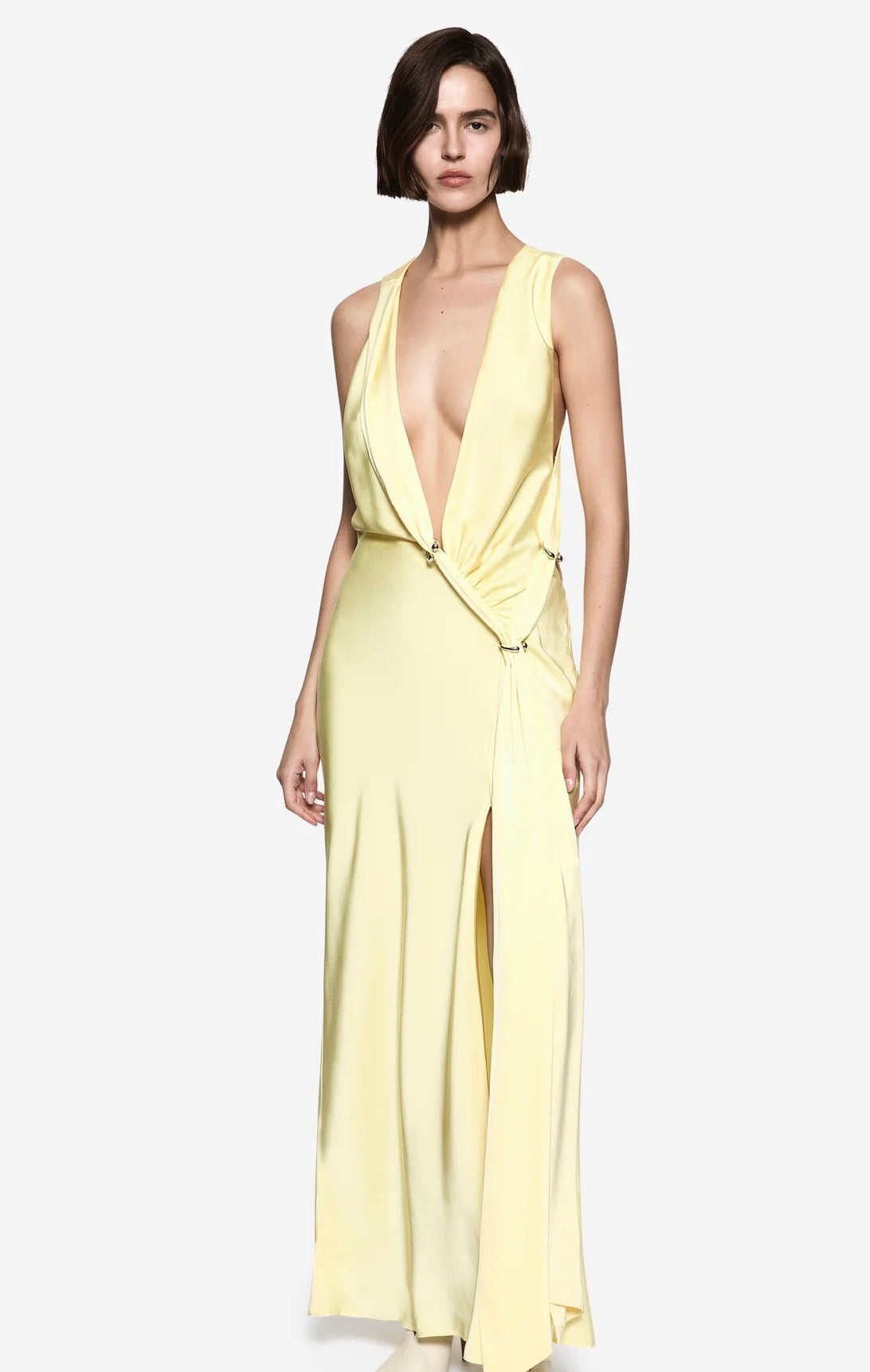 Women standing in front of a white backdrop in q yellow maxi satin dress.