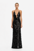 A model wearing a floor-length black sequined gown with thin straps, a plunging neckline with a small keyhole cutout, and a fitted silhouette, photographed against a plain light gray studio background.