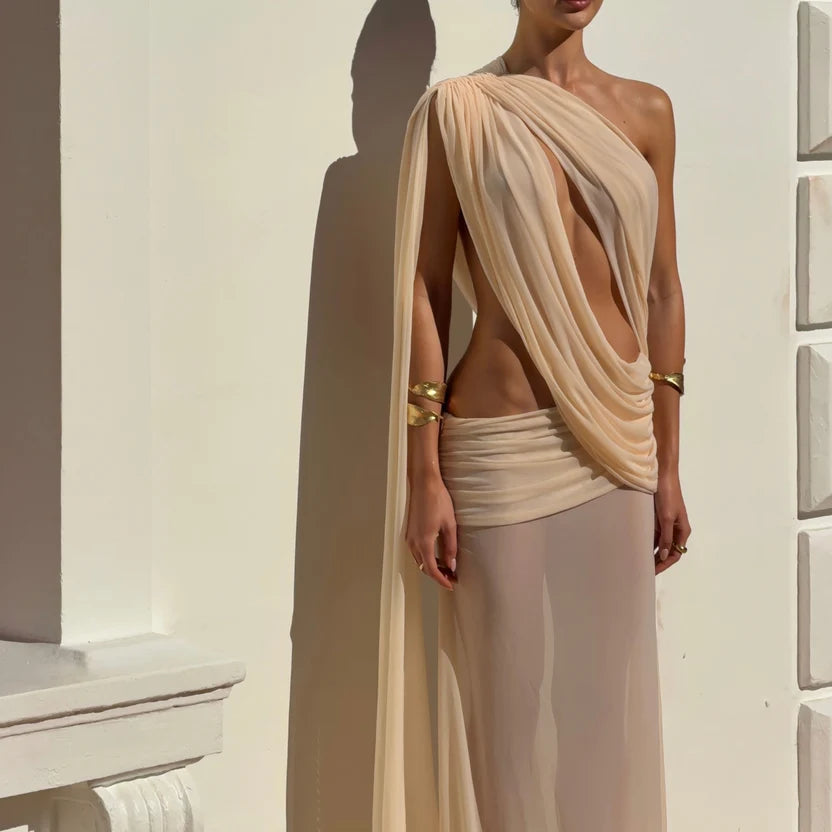 Girl standing in a mesh dress set in front of a white wall.