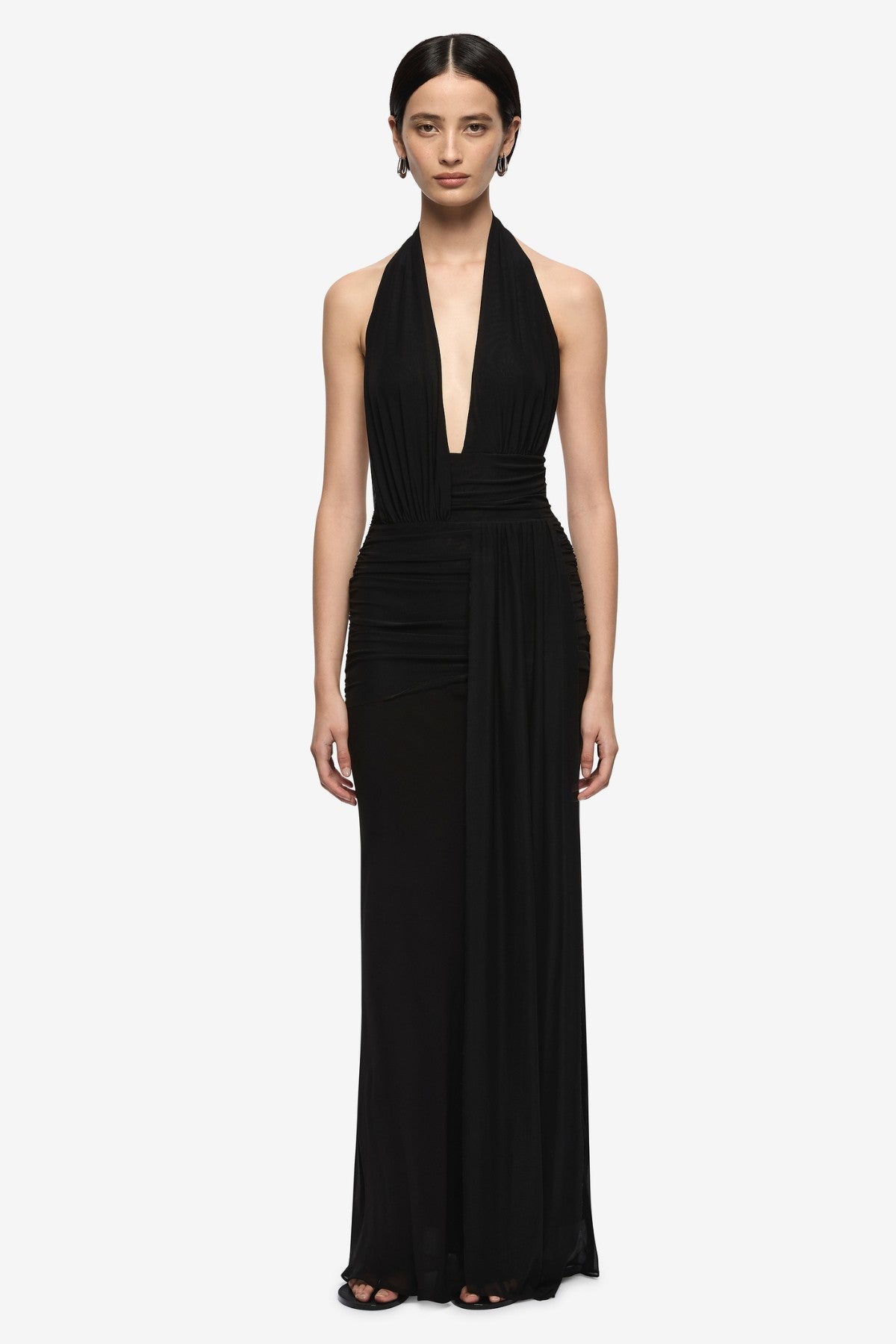 Woman wearing a black halter neck gown on a white background