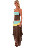 Woman wearing a colorful dress with a brown base and blue and yellow accents on a white background