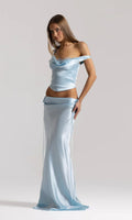 Model wearing the Natalie Rolt Evelyn Skirt in Ice Blue, a full-length bias-cut silk skirt featuring draped waist detailing and elongated side ties, styled with the matching Posy Top.
