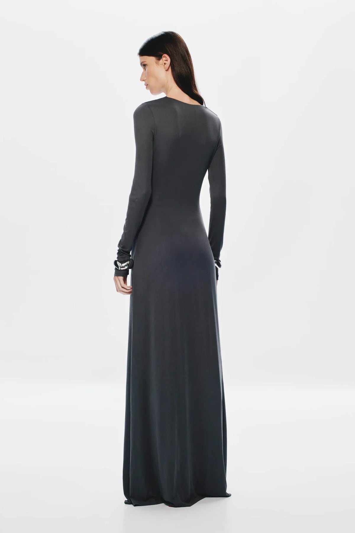 Woman wearing a long dark gray dress on a white background