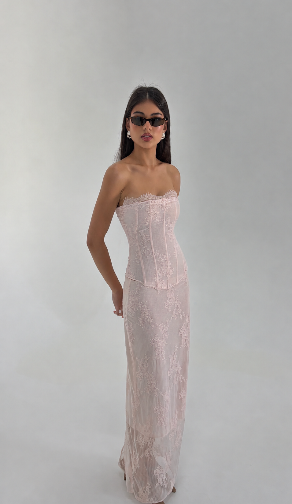 Model wearing the HNTR The Label Inez Corset and Maxi Skirt in blush pink embroidered lace.
