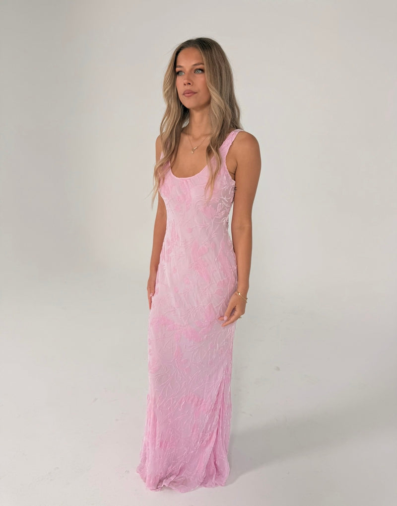 A woman modeling a light pink sleeveless maxi dress with a textured, crinkled fabric, standing against a plain white studio background. - @indiabluegranger