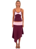 Woman wearing the Camilla Knit Set in pink and purple, featuring a fitted sweetheart neckline tank top with thin straps and a contrasting low-waisted asymmetric midi skirt, styled with brown strappy heels against a white background.