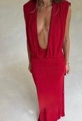 Woman wearing a vibrant red floor-length maxi dress featuring a deep plunging V-neckline, softly draped sleeveless bodice, gathered waist and fitted skirt, taking a mirror selfie against a neutral background.