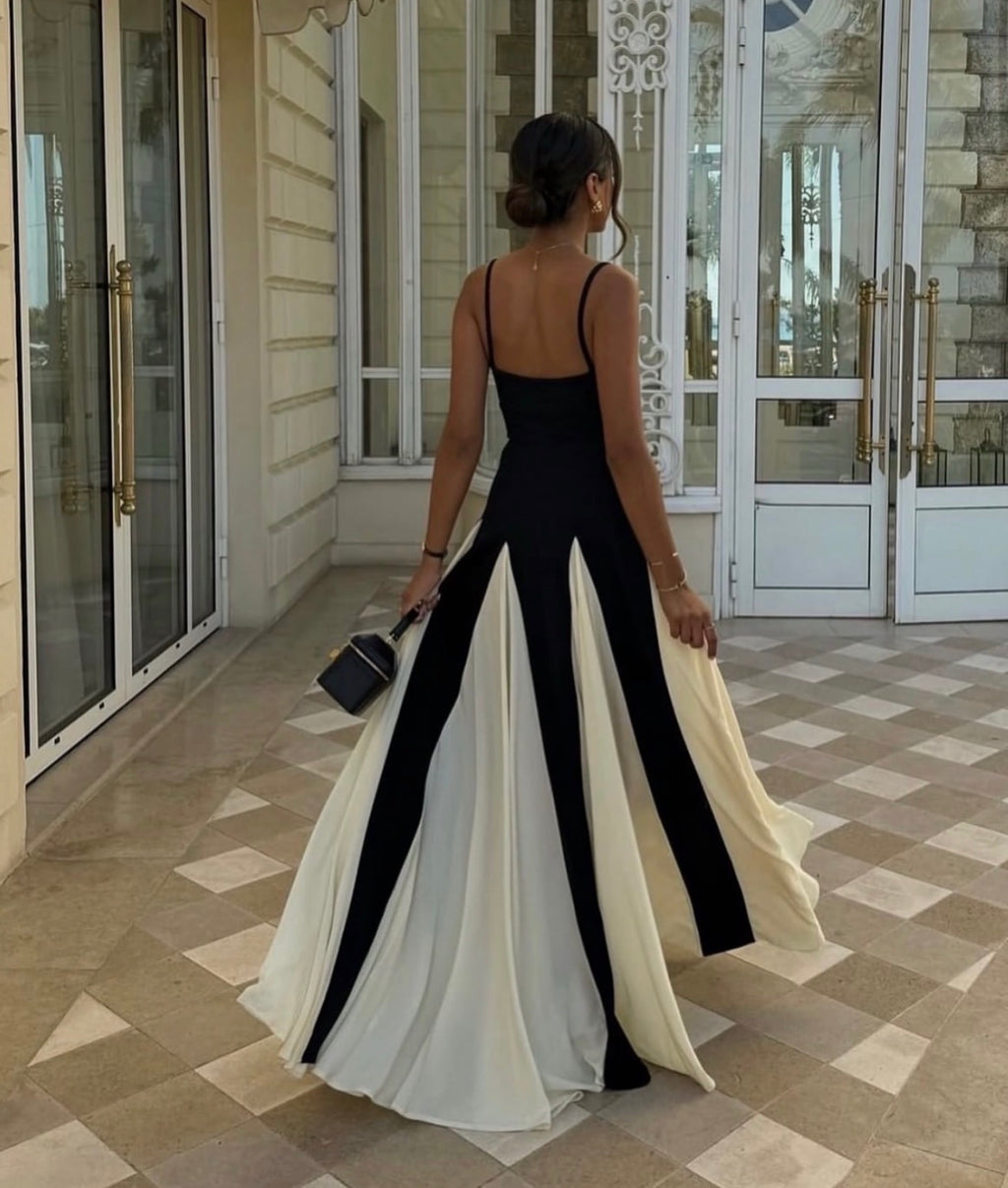 Woman in a black and white dress standing in front of a building entrance.