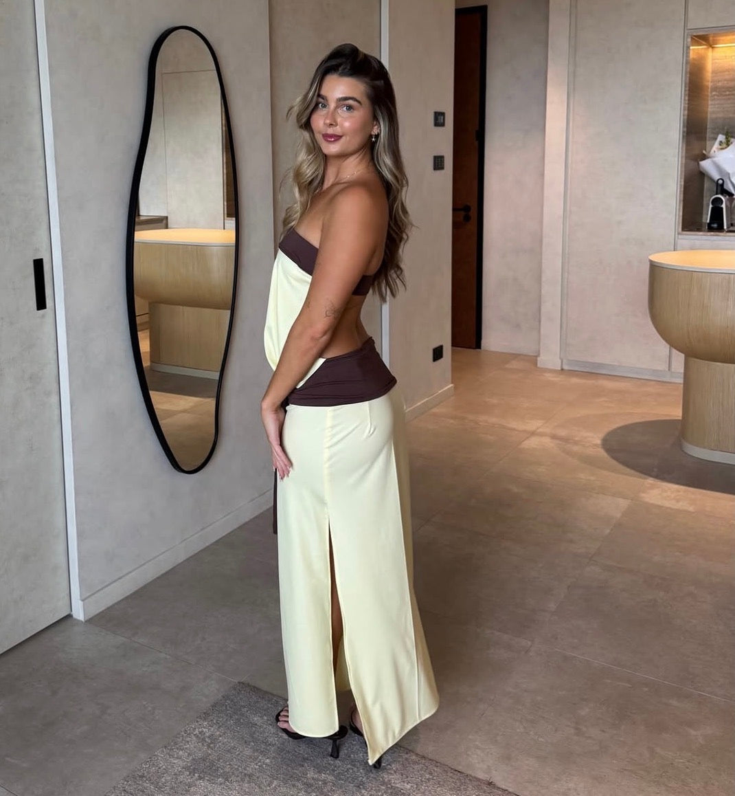 Woman in a stylish outfit standing in a modern interior setting.