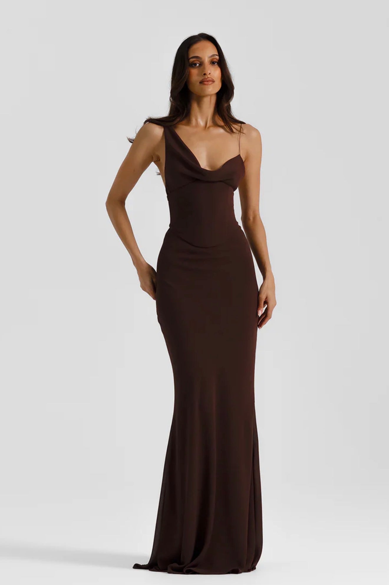Woman wearing a brown evening gown against a white background