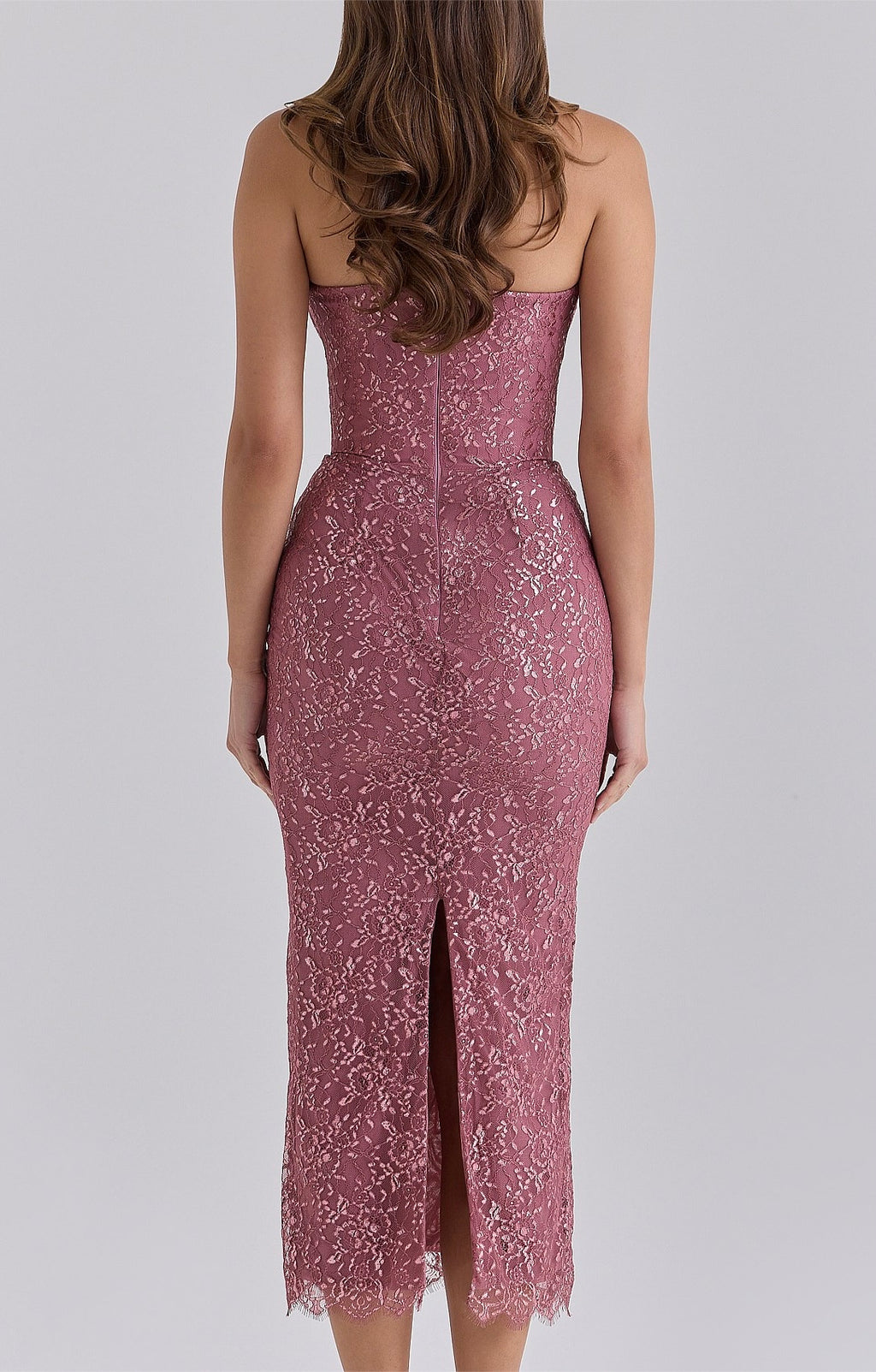 Back view of the House of CB Alexia Amethyst Metallic Lace Strapless Midi Dress in dusty rose pink, featuring shimmering floral lace, a fitted silhouette, centre-back zip closure, rear slit and delicate scalloped lace hem against a light grey studio background.