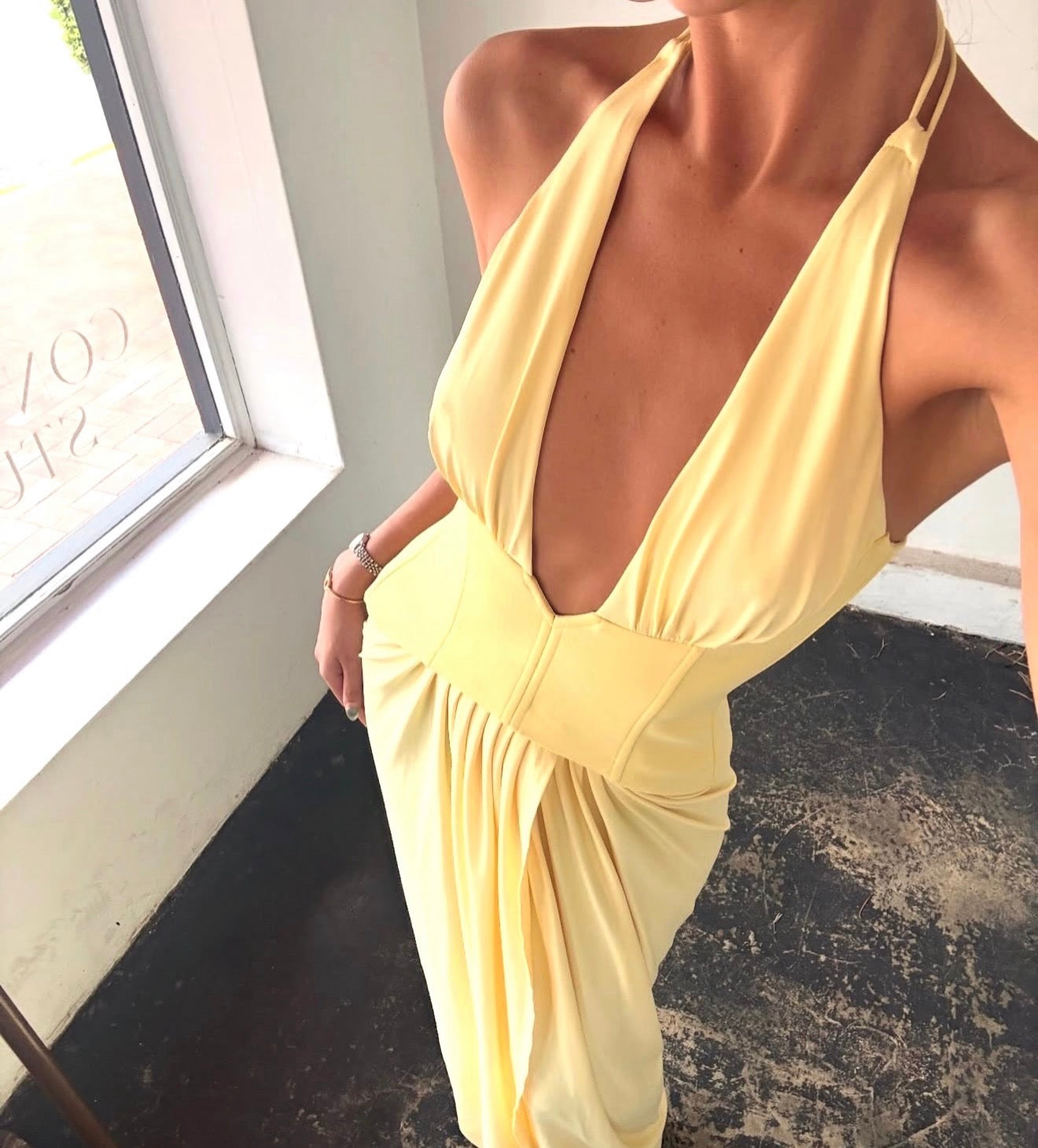 Yellow dress with a deep neckline worn by a person indoors.