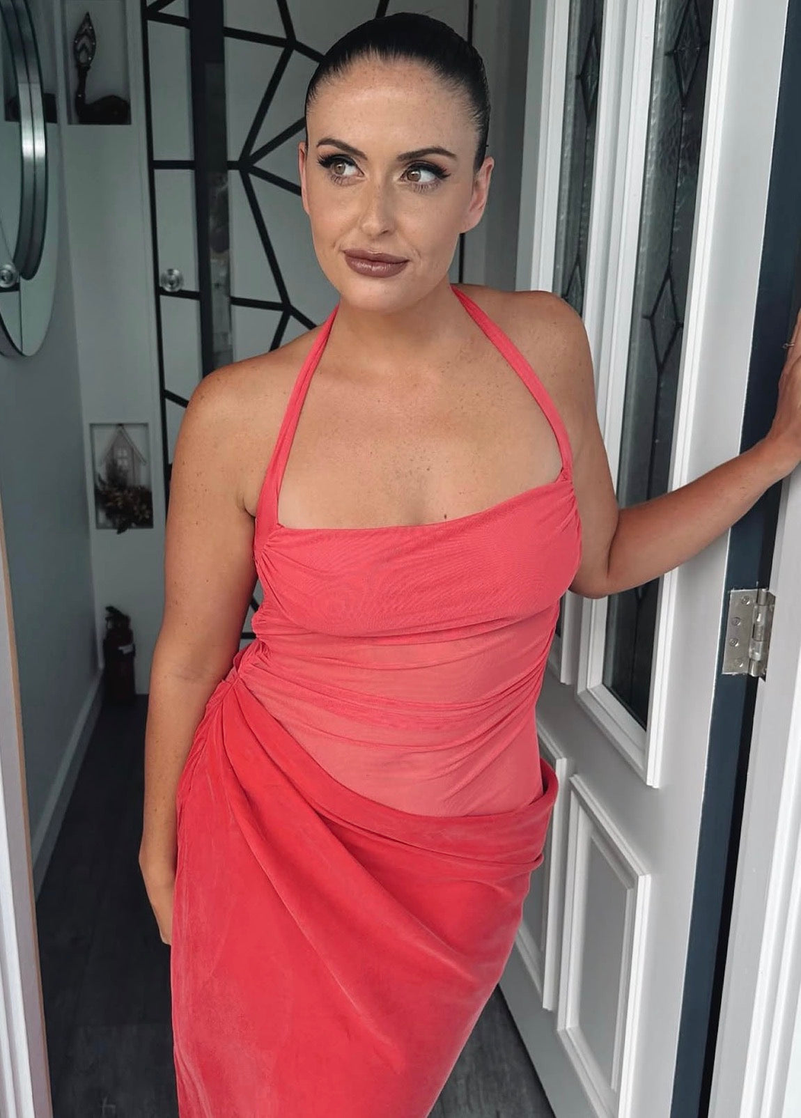 Woman in a pink dress standing in a doorway. - @gabmoore