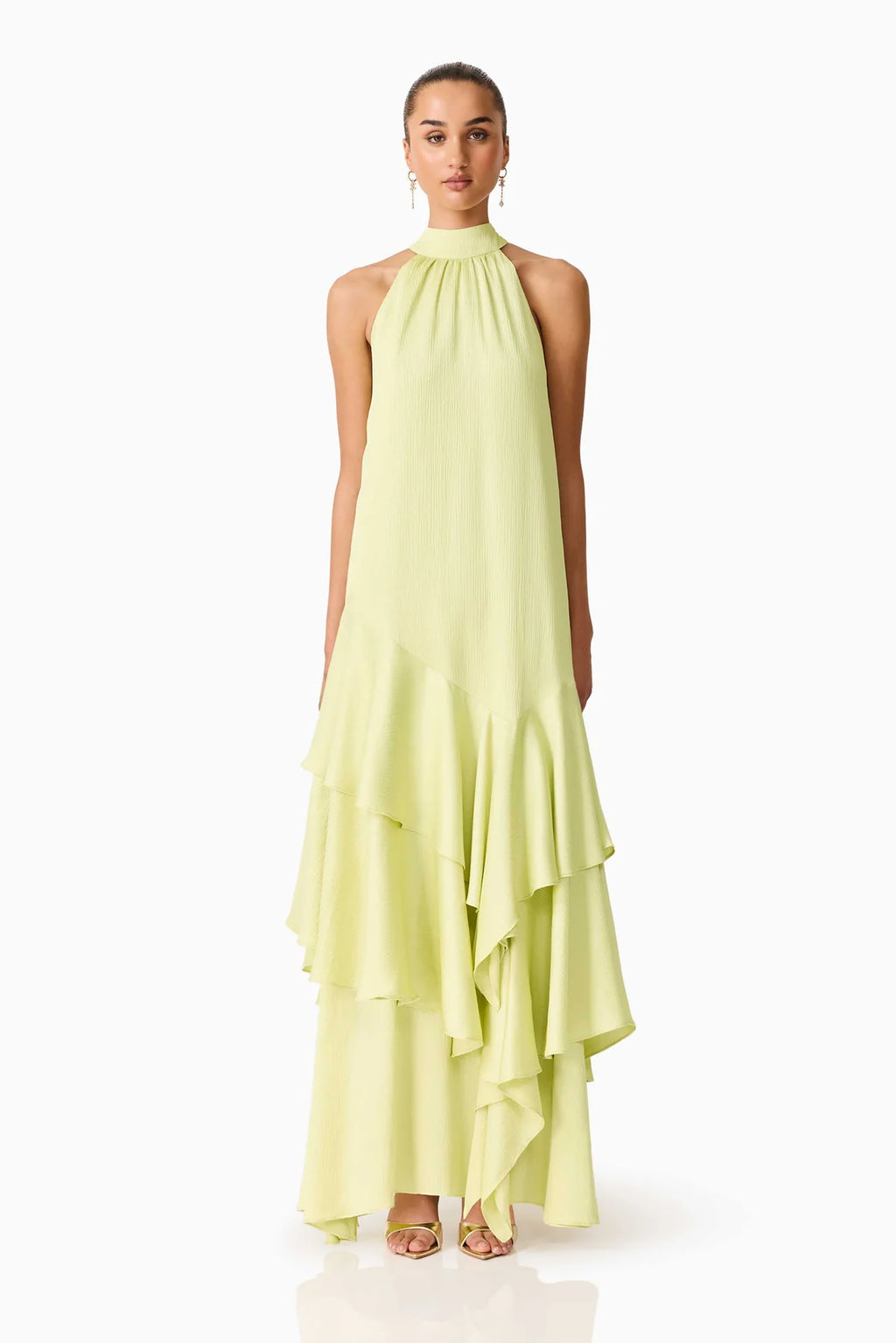 Women standing in front of a white backdrop in a green halter neck maxi dress