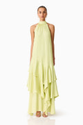 Women standing in front of a white backdrop in a green halter neck maxi dress
