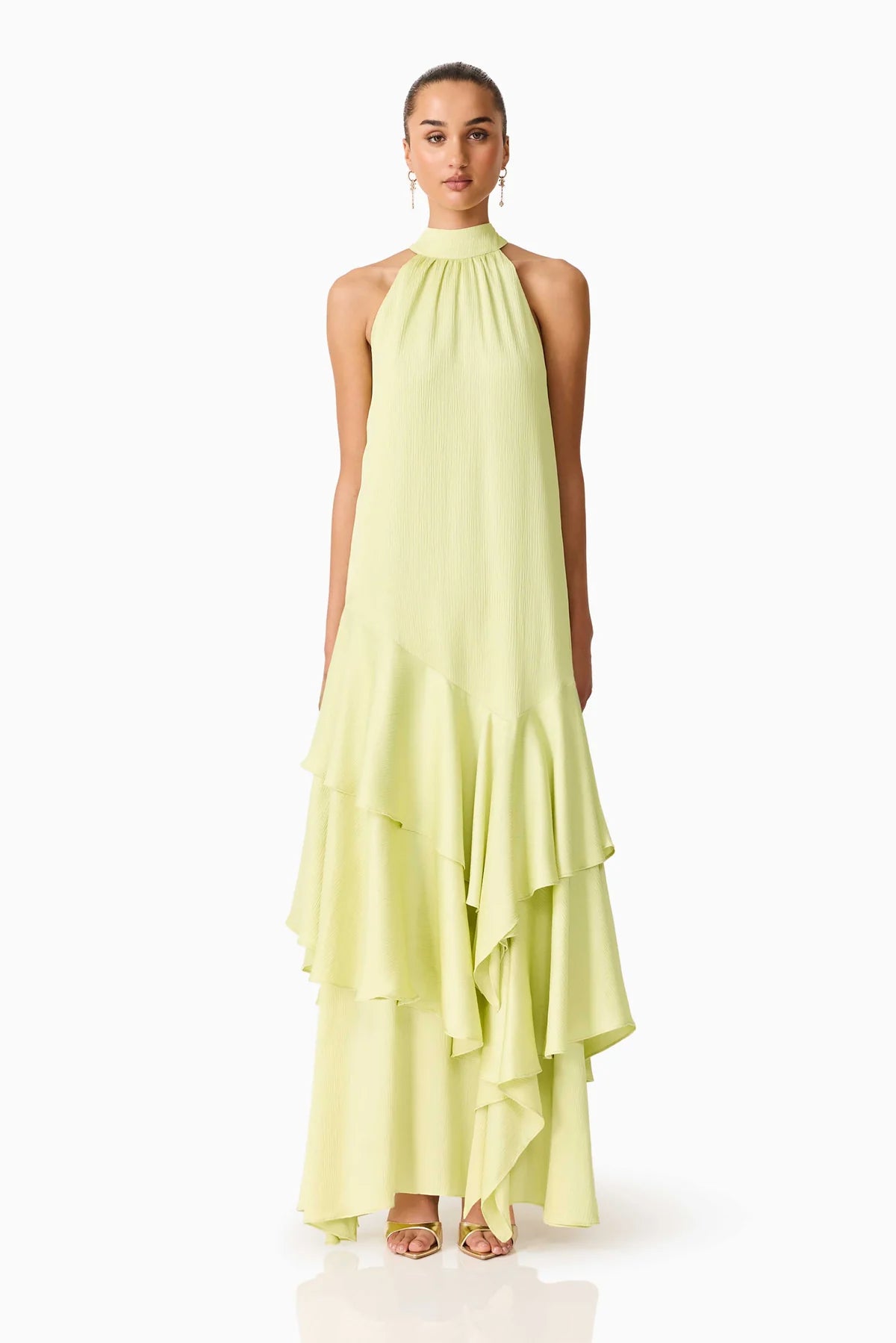 Women standing in front of a white backdrop in a green halter neck maxi dress